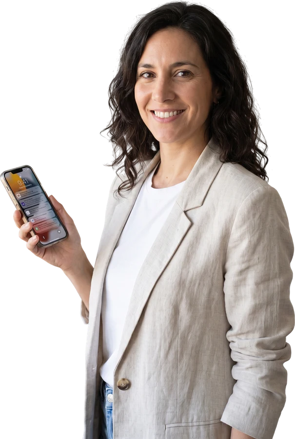Agente inmobiliaria sonriendo con el celular en la mano (imagen ilustrativa)